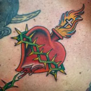 n American traditional sacred heart tattoo with a crown of thorns, bold lines, and solid colors, by artist Zach Westcott.