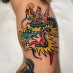 A custom tattoo of a dragon head and dagger, a custom piece by Jacksonville tattoo artist Tim Shafer.
